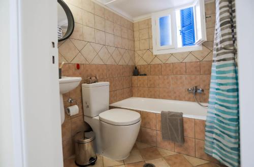a bathroom with a toilet and a tub and a sink at Rhodes Town Garden Apartment in Rhodes Town