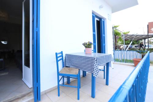 a blue table and chairs on a porch with a table and a window at Rhodes Town Garden Apartment in Rhodes Town