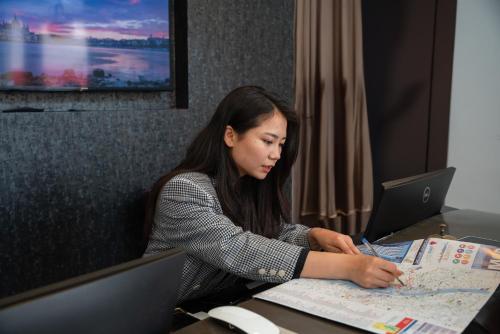 a woman sitting at a table with a laptop at Hotel Memories Budapest in Budapest