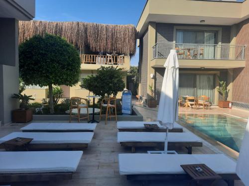 um resort com uma piscina e espreguiçadeiras e um guarda-sol em SEREN OTEL ÇEŞME em Cesme