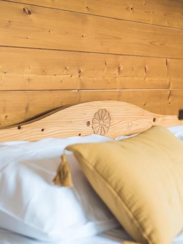 a bed with a wooden headboard and a pillow at Auberge Le Valezan in Valezan