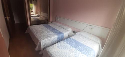 two beds in a small room with a mirror at Raquel Inn - Garaje incluido in Avilés