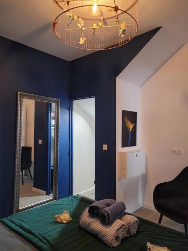 um quarto com paredes azuis, um espelho e uma cama em île en Provence em Martigues