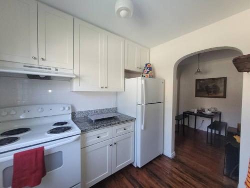 a kitchen with white cabinets and a white refrigerator at Moon Lakeview Apt at Crescent Lk in St Petersburg