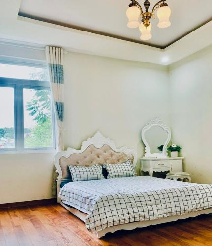 ein Schlafzimmer mit einem weißen Bett und einem Fenster in der Unterkunft Golden Hills A2200 in Da Lat