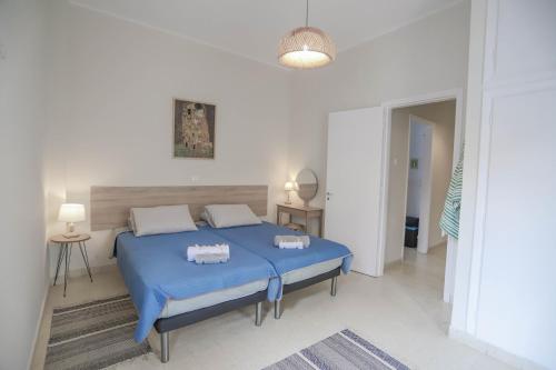 a bedroom with a blue bed in a white room at Traditional Town Garden Apartment in Rhodes Town