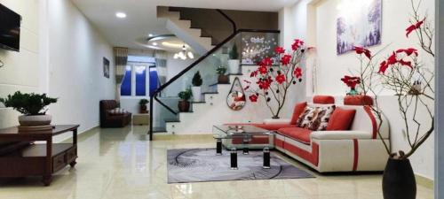 ein Wohnzimmer mit einem Sofa und einer Treppe in der Unterkunft Golden Hills A2200 in Da Lat