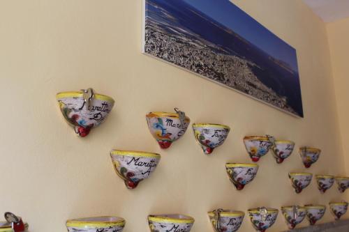 a group of cups hanging on a wall at Hotel Residence Le Chiavi Di San Francesco in Trapani