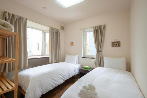 a bedroom with two beds and a window at Asuka Value Apartments in Kutchan