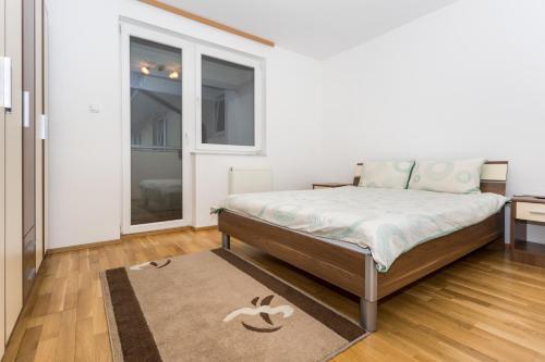 a bedroom with a bed and a window and a rug at Urban Escape in Vogošća
