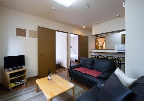 a living room with a couch and a table at Asuka Value Apartments in Kutchan