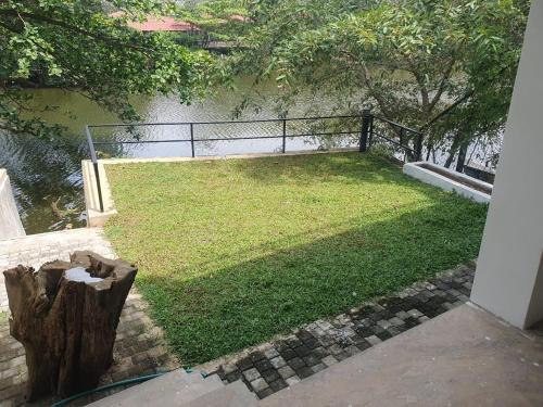 a view of a yard with grass and a fence at River Front Villa in Wadduwa