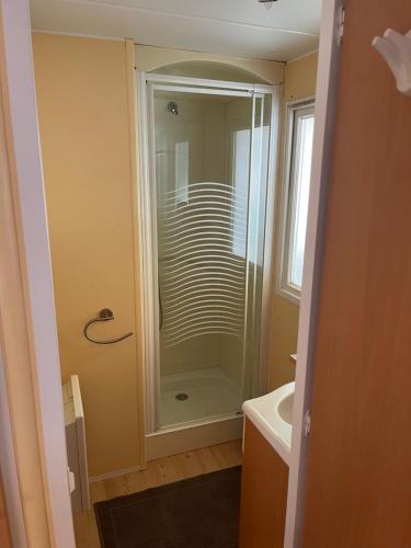 La salle de bains est pourvue d'une douche et d'un lavabo. dans l'établissement Joli Mobil-home climatisé entièrement équipé, sauf draps en option, pour 4 adultes au maximum avec possibilité de 2 enfants en plus, à Sarlat-la-Canéda