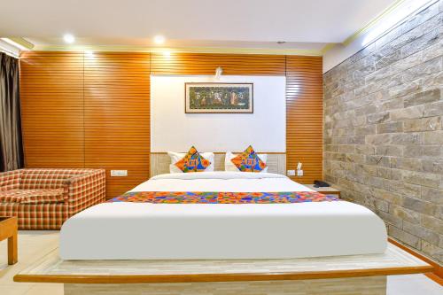 a bedroom with a large bed and a brick wall at FabHotel Fly View in Jaipur