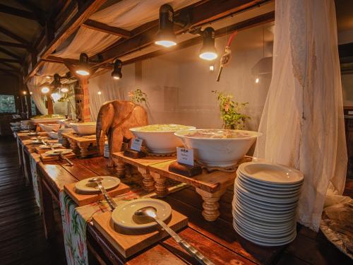 a row of bowls and plates on a table at Nkambeni Safari Camp in Hazyview
