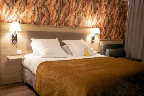 a hotel room with a large bed with a yellow sign on it at Golden Tulip Troyes in Barberey-Saint-Sulpice