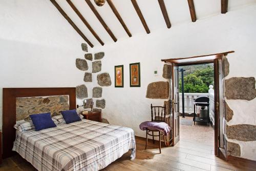 ein Schlafzimmer mit einem Bett mit blauen Kissen darauf in der Unterkunft La casa nueva in Fataga