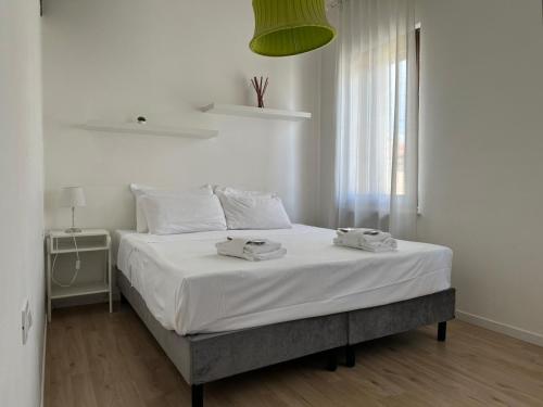 sypialnia z łóżkiem z białą pościelą i oknem w obiekcie Welc-ōm Santa Giustina apartment w Padwie