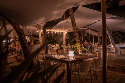 a restaurant with tables and chairs under a tent at Ness by D-Ocean in Saint-Gilles les Bains