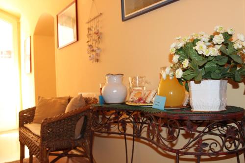 a table with flowers and vases on top of it at Hotel Residence Le Chiavi Di San Francesco in Trapani