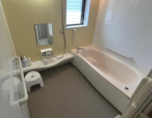 uma casa de banho com uma banheira, um WC e um lavatório. em オオヤシロSTAY旅音 em Izumo