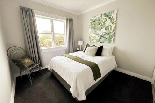 a bedroom with a large bed and a window at The Tirau Cottage - Waikato in Tirau