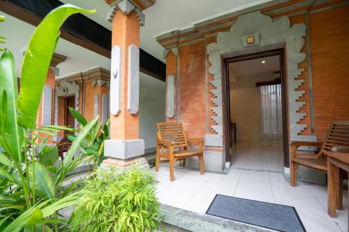 a porch of a house with chairs and plants at Hotel Sinar Bali Legian in Legian