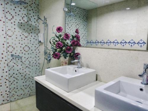 a bathroom with a sink and a vase of flowers at Regalia Skypool KLCC in Kuala Lumpur