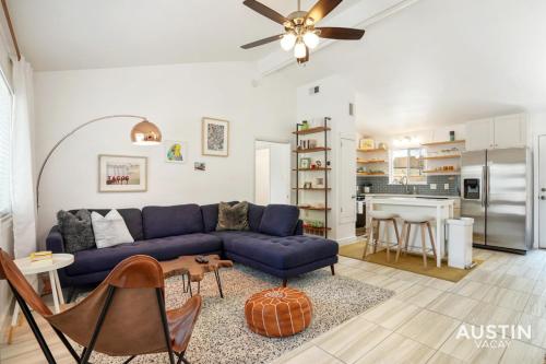 a living room with a blue couch and a kitchen at Stylish Austin Retreat w Luxurious King Bed and WD in Austin