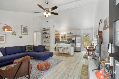 a living room with a blue couch and a kitchen at Stylish Austin Retreat w Luxurious King Bed and WD in Austin