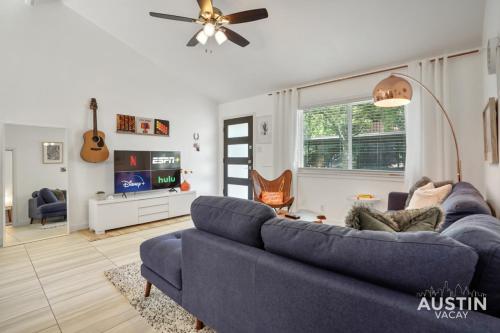 a living room with a blue couch and a tv at Stylish Austin Retreat w Luxurious King Bed and WD in Austin