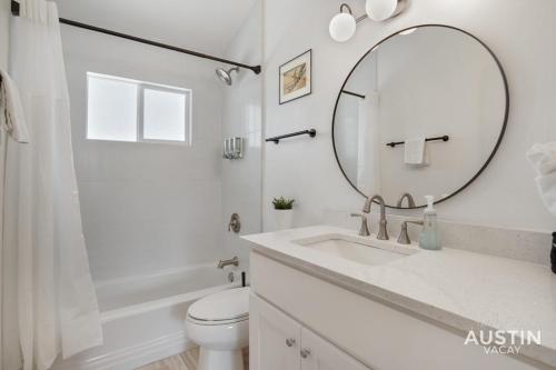a white bathroom with a sink and a mirror at Stylish Austin Retreat w Luxurious King Bed and WD in Austin
