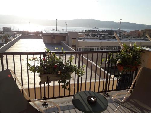 un balcón con una mesa y macetas. en B&B Vistamare, en Villa San Giovanni