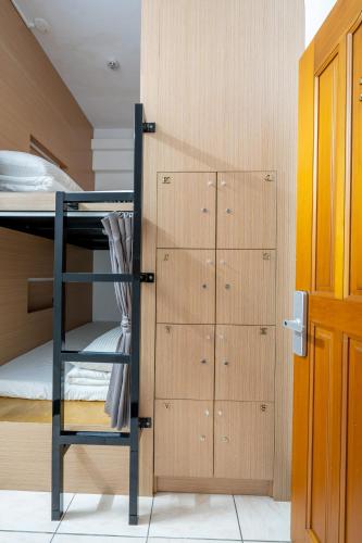 a bunk bed with a ladder next to a locker at Utopia Hostel in Taitung City