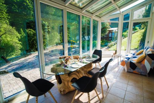 un salón acristalado con mesa de cristal y sillas en Estate Žagmeštri, en Ljubno