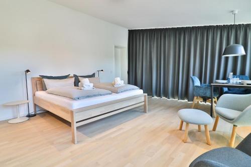 Schlafzimmer mit einem Bett, einem Tisch und Stühlen in der Unterkunft Lüttjeod - Apartment 11 in Langeoog