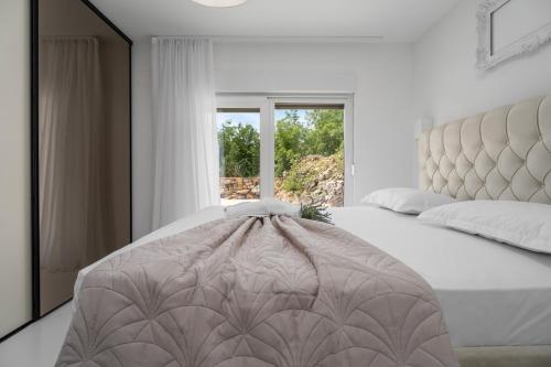 a bedroom with a large bed and a window at NEW Villa Begovina with a private pool, Hot-Tub, 4 bedrooms in Krivodol