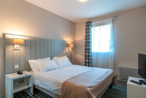ein Hotelzimmer mit einem Bett und einem Fenster in der Unterkunft Les Sables 504 - Appt avec piscine partagée in Concarneau