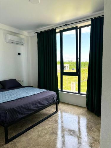 1 dormitorio con cama y ventana grande en HeyShekvetili, en Shekhvetili