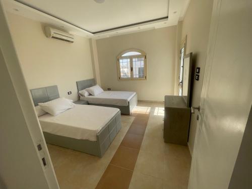 a bedroom with two beds and a window at Moubark 6 Villa 1 in Hurghada