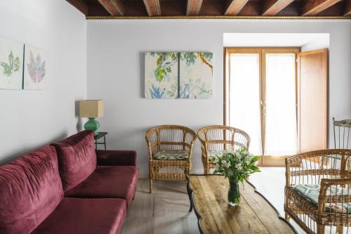 een woonkamer met een bank, stoelen en een tafel bij numa I Molina Apartments in Sevilla