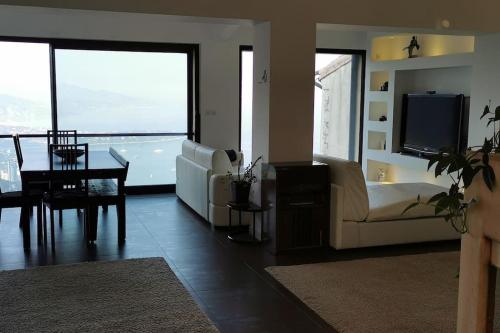 uma sala de estar com um sofá, uma televisão e uma mesa em Villa with unique & breathtaking view over Sea, Monte-Carlo, Italy & Alps em La Turbie