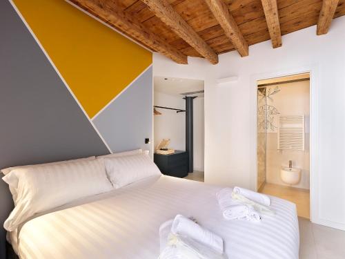 a bedroom with a white bed and a yellow wall at SG9 CITY APARTMENTS in Brescia
