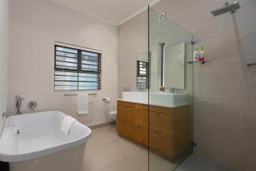 y baño con bañera, lavamanos y ducha. en Albert Road 14 en Ciudad del Cabo