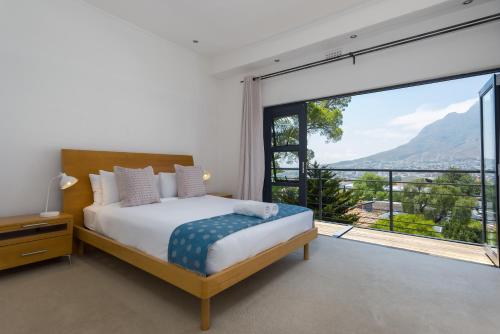 a bedroom with a bed and a large window at Albert Road 14 in Cape Town