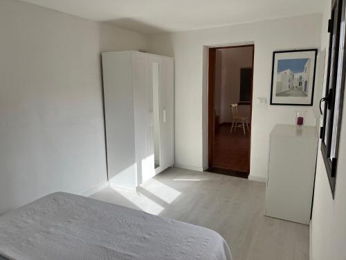 ein weißes Zimmer mit einem Bett und einer Tür in der Unterkunft Casa LiaLara Mare in Augusta
