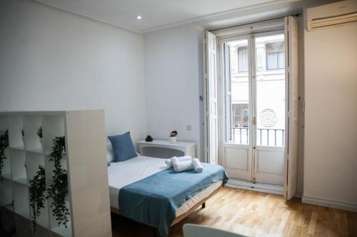sypialnia z łóżkiem i dużym oknem w obiekcie Apartments Madrid Principe 2 w Madrycie