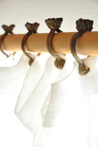 a wooden curtain rod with white curtains at Sny pod jasany in Horní Řasnice