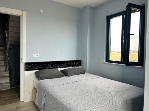 - une chambre blanche avec un lit et une fenêtre dans l'établissement Enez Trapezde Kiralık Müstakil Villa, à Enez
