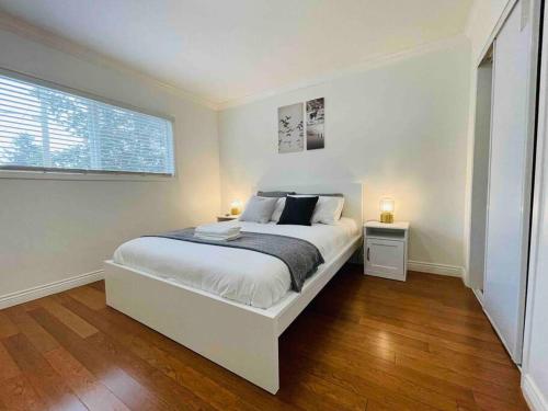 a white bedroom with a bed and a window at Luxury North Vancouver 3 bedroom Up Level House in North Vancouver